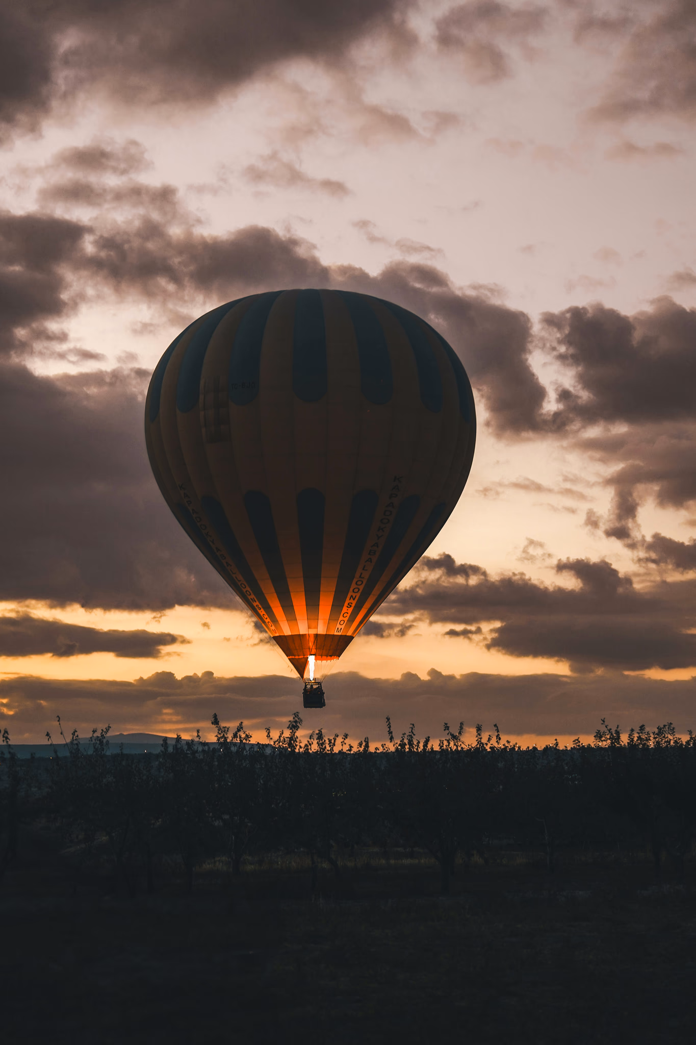 A large hot air balloon flying through a cloudy sky